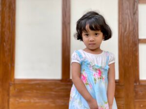 Portrait of cute asian kid in colorful dress