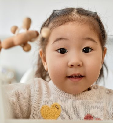Asian little girl playing with toys